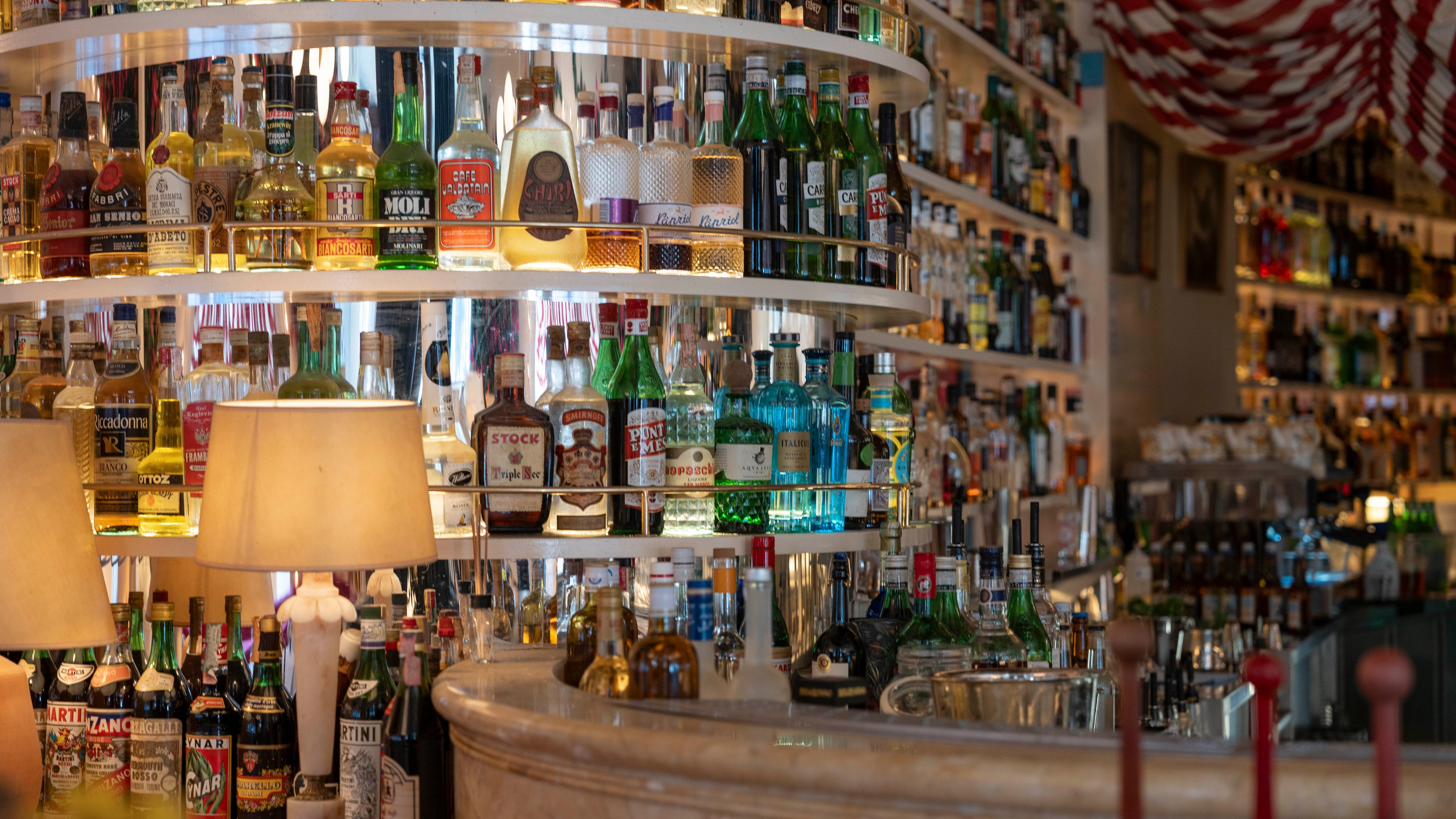 Vue détaillée des nombreuses rangées de bouteilles à l’intérieur du Splendido, comptant une sélection de spiritueux et de liqueurs, et mises en valeur par un éclairage chaleureux et des éléments décoratifs.