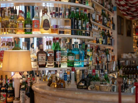 Vue détaillée des nombreuses rangées de bouteilles à l’intérieur du Splendido, comptant une sélection de spiritueux et de liqueurs, et mises en valeur par un éclairage chaleureux et des éléments décoratifs.