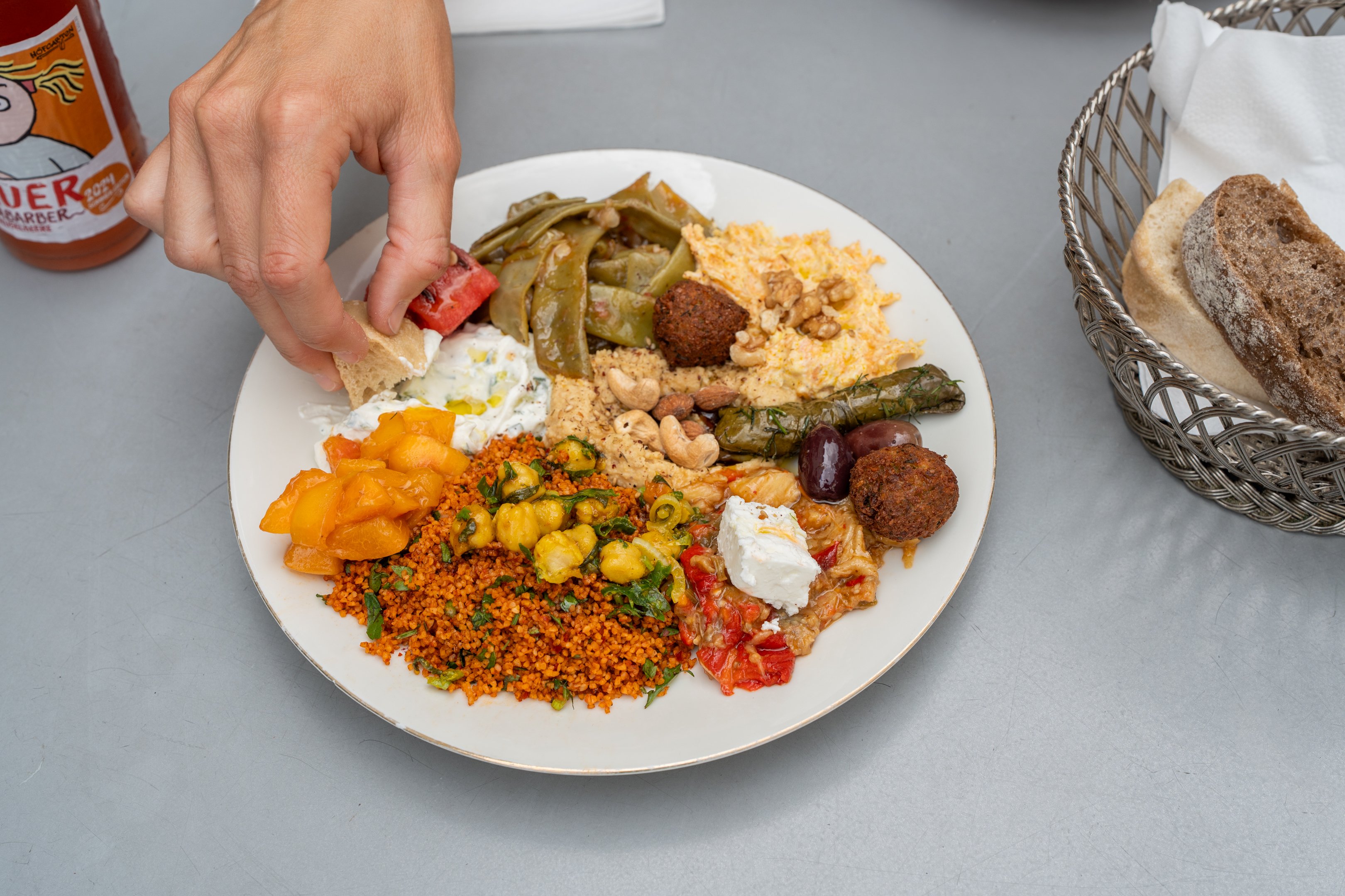 Plateau de mezzés mixtes. Pain trempé à la main dans une sauce blanche.