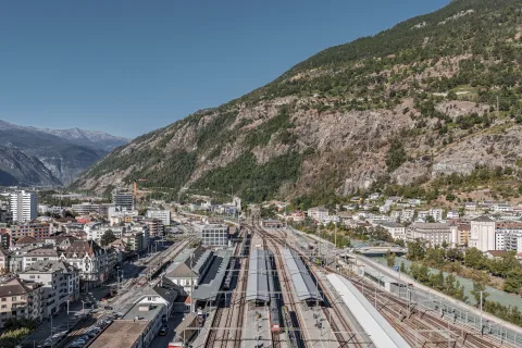 Blick von oben auf die Gleise und Perrons des Bahnhofs Brig.