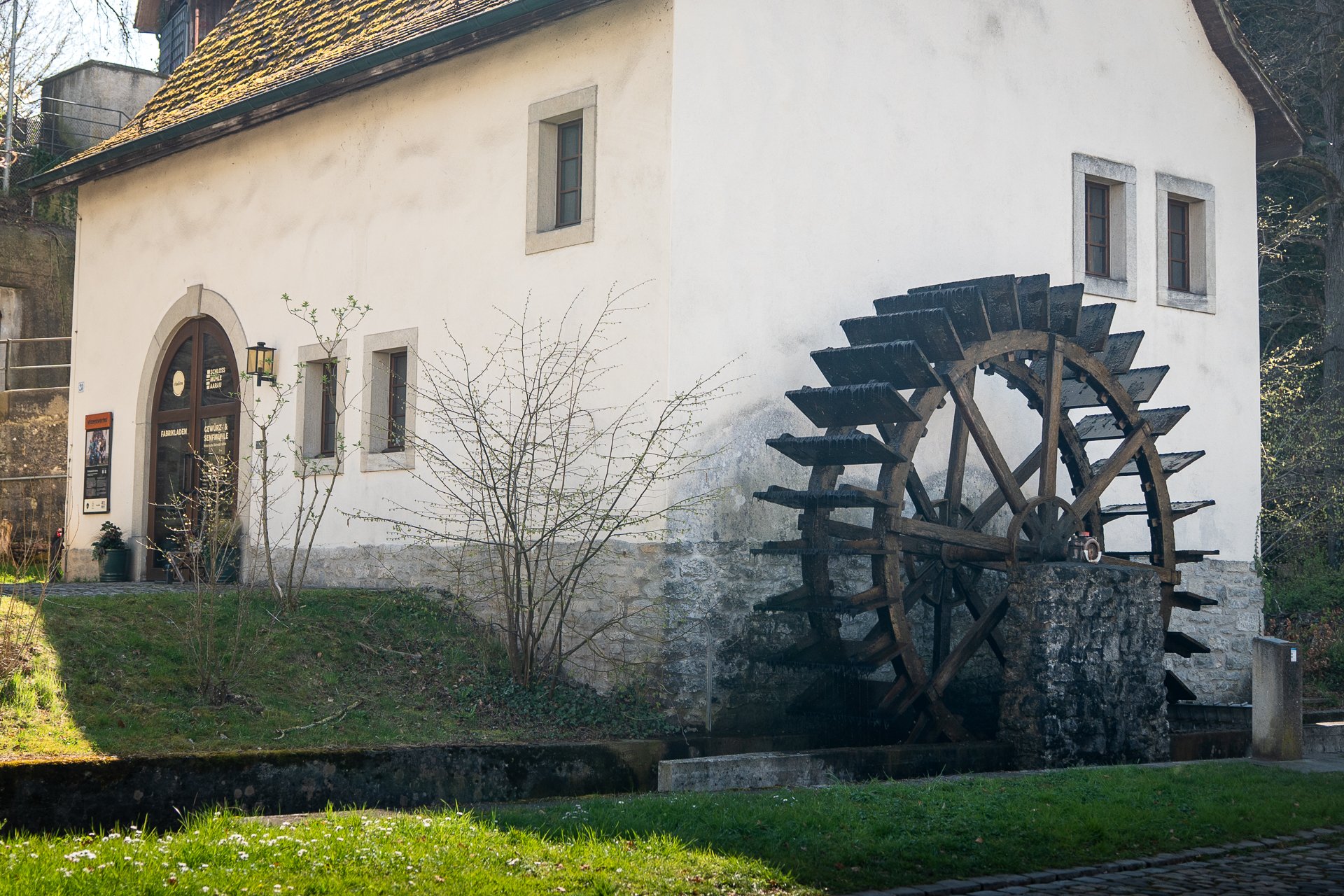 Ein historisches Haus mit einem seitlich angebrachten Mühlenrad.