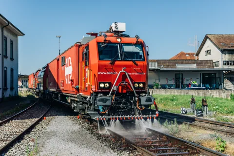 Un train d’extinction et de sauvetage franchit les voies. De l’eau pulvérise les rails à l’avant de la locomotive pour les refroidir.