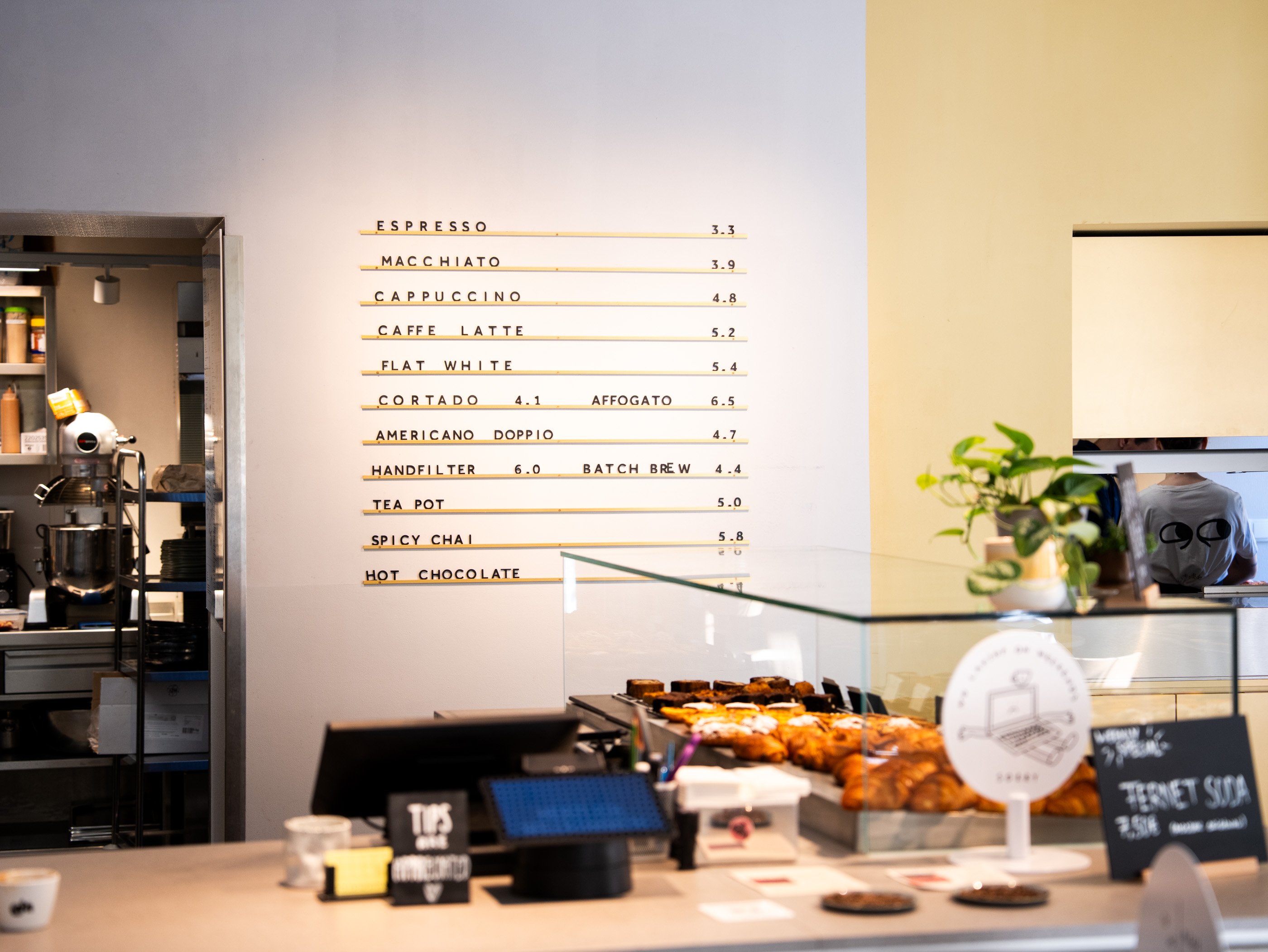 Gli interni minimalisti del goldener papagei di Vienna con il menu degli specialty coffee.