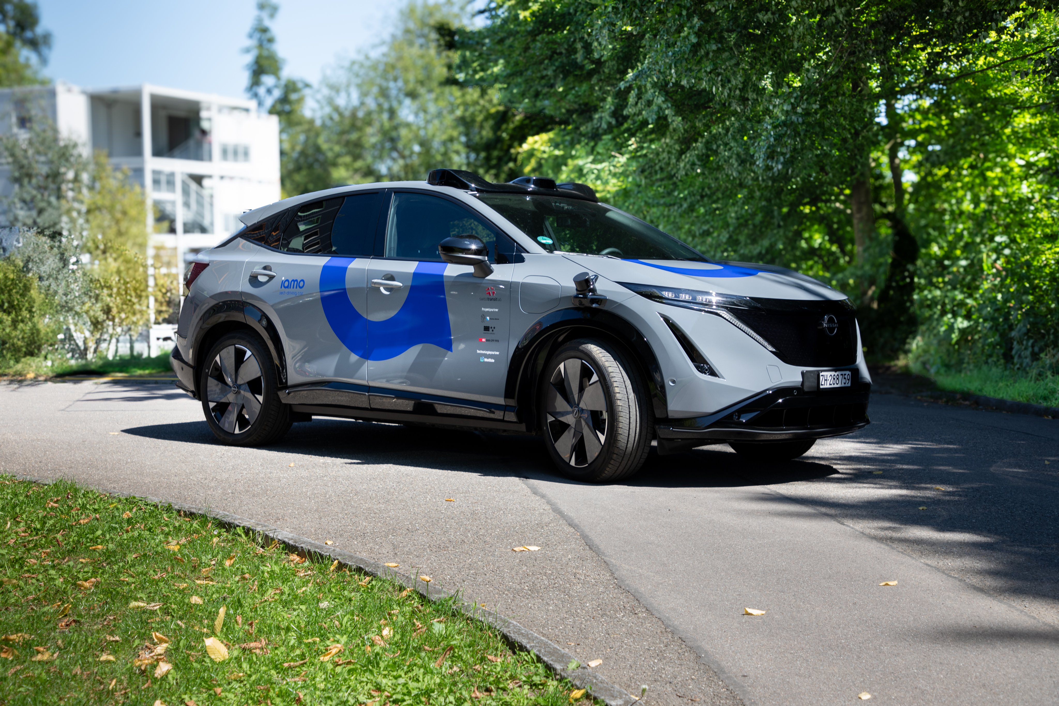 Ein iamo-Auto der Marke Nissan steht auf einer Strasse.