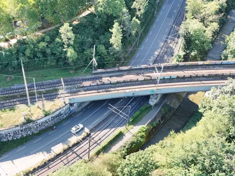Das Foto zeigt zwei parallel verlaufende Brücken. Sie werden von einer Strasse, zwei Tramgleisen und einem Fluss unterquert.