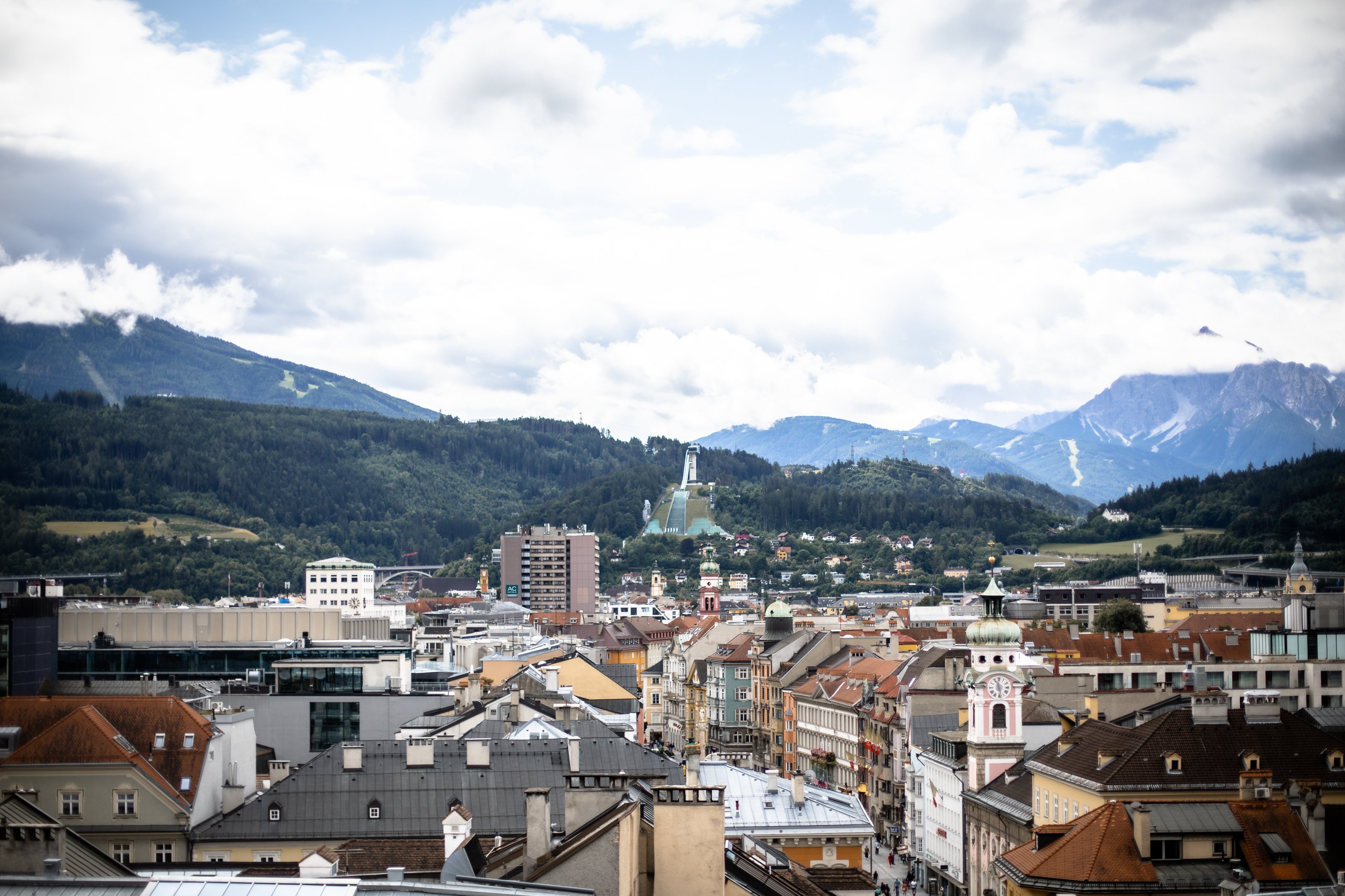 Aussicht über die Stadt bis zur Skispungschanze und den Bergen dahinter.