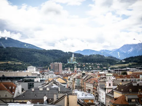 Aussicht über die Stadt bis zur Skispungschanze und den Bergen dahinter.