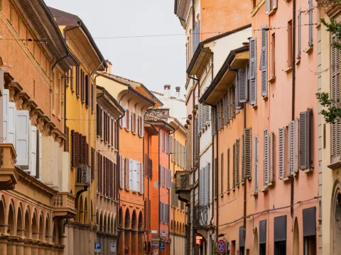 Narrow alley with colourful facades and wooden shutters