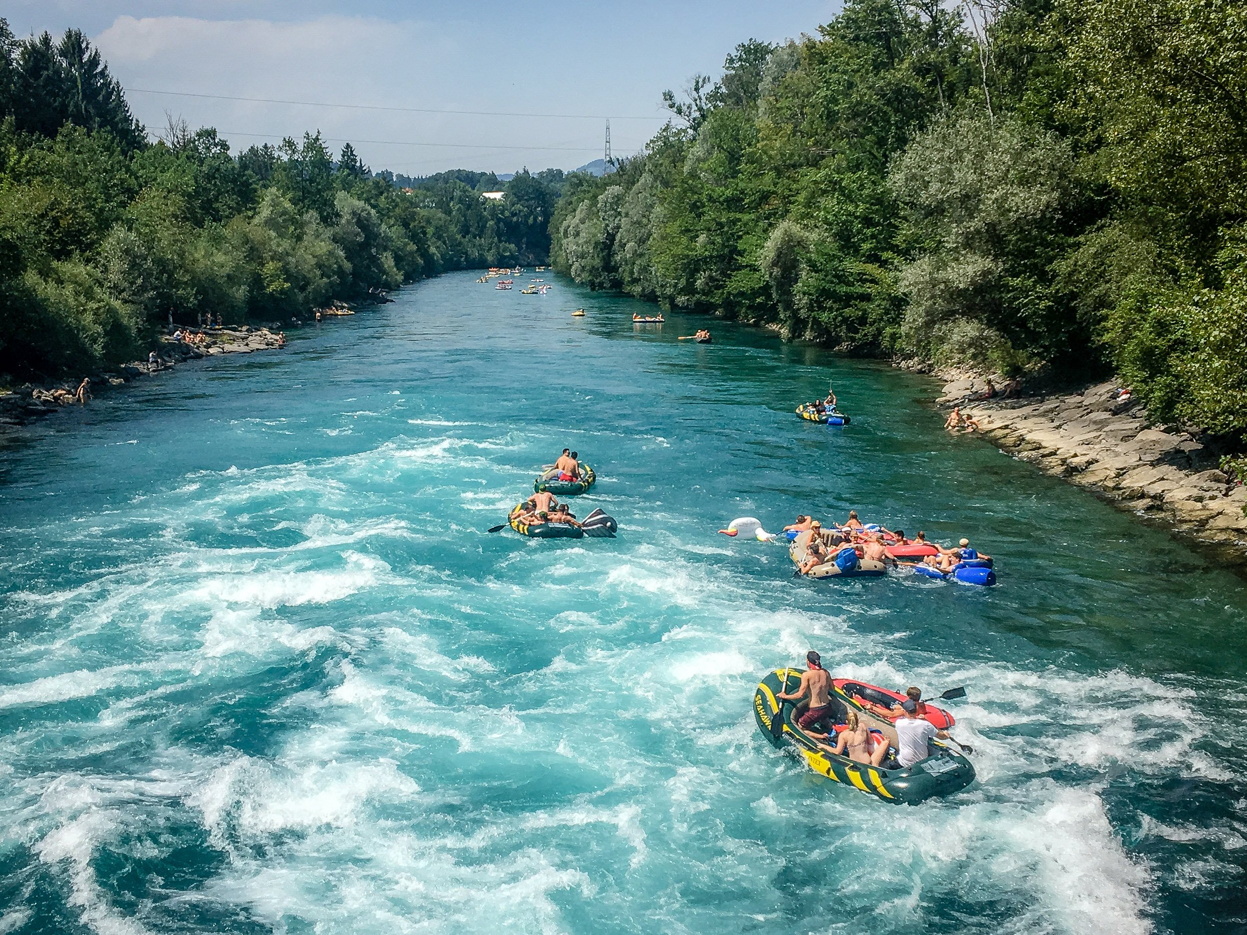 Zwei Menschen stehen an der Aare und schauen zum Münster.