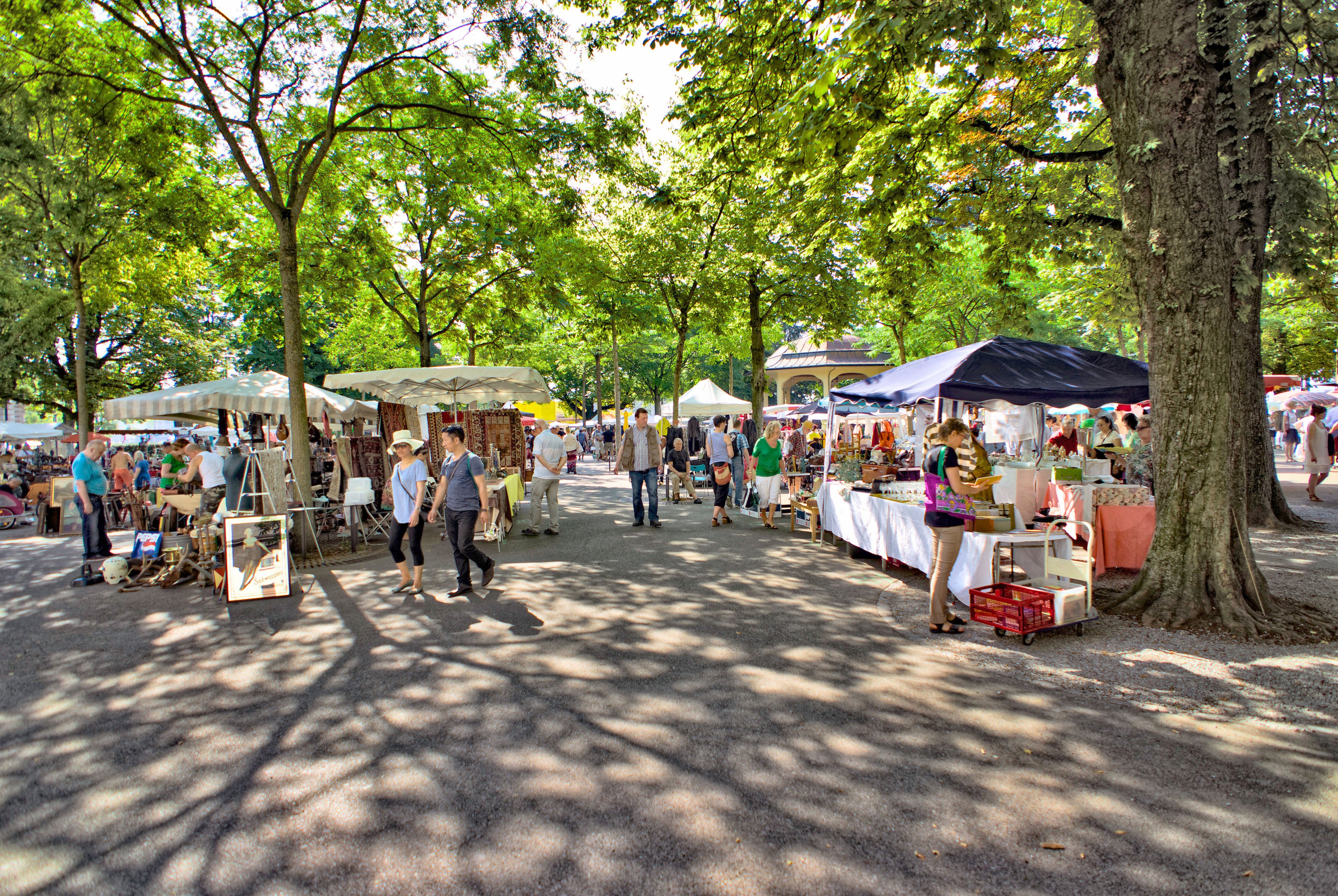 Menschen schlendern an Verkaufsständen vorbei am Flohmarkt Bürkliplatz.