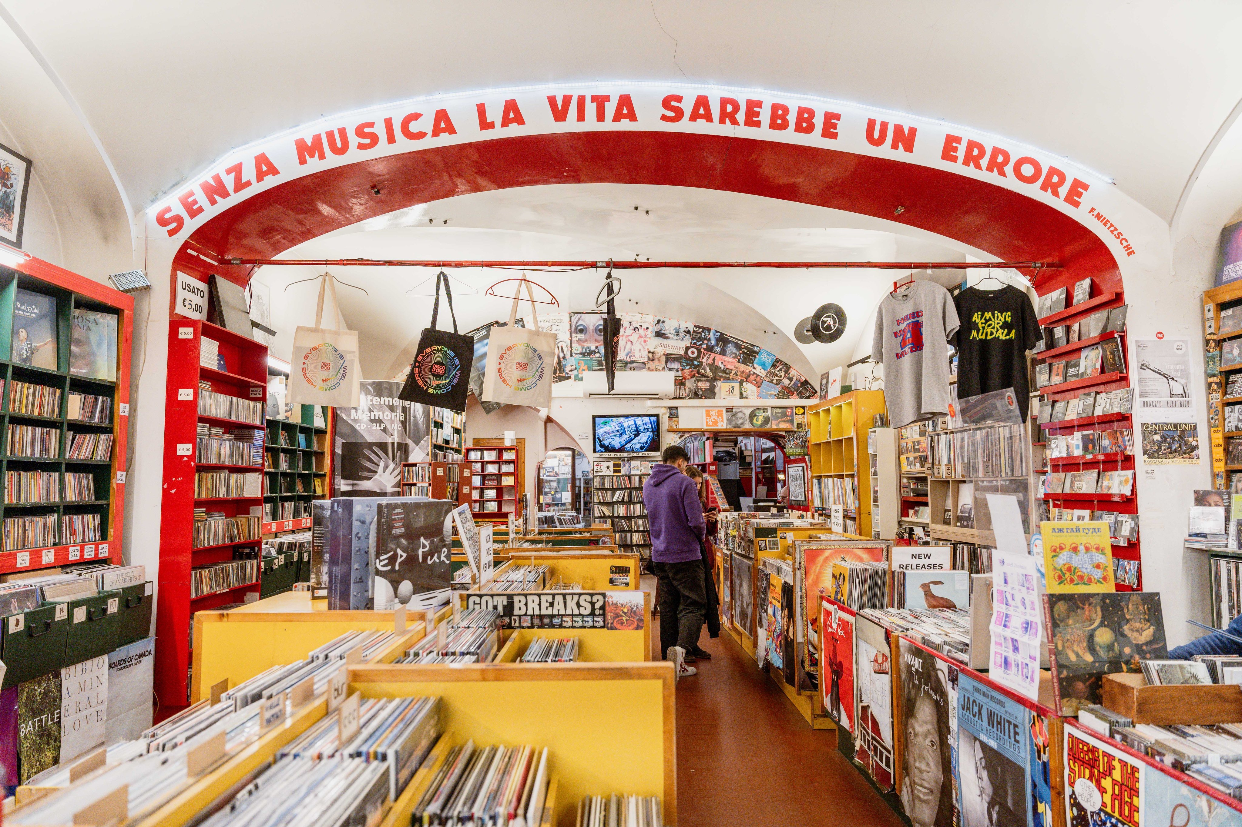 Record shop with vinyl, CDs and music posters under a vaulted ceiling.