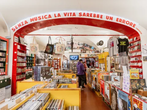 Record shop with vinyl, CDs and music posters under a vaulted ceiling.