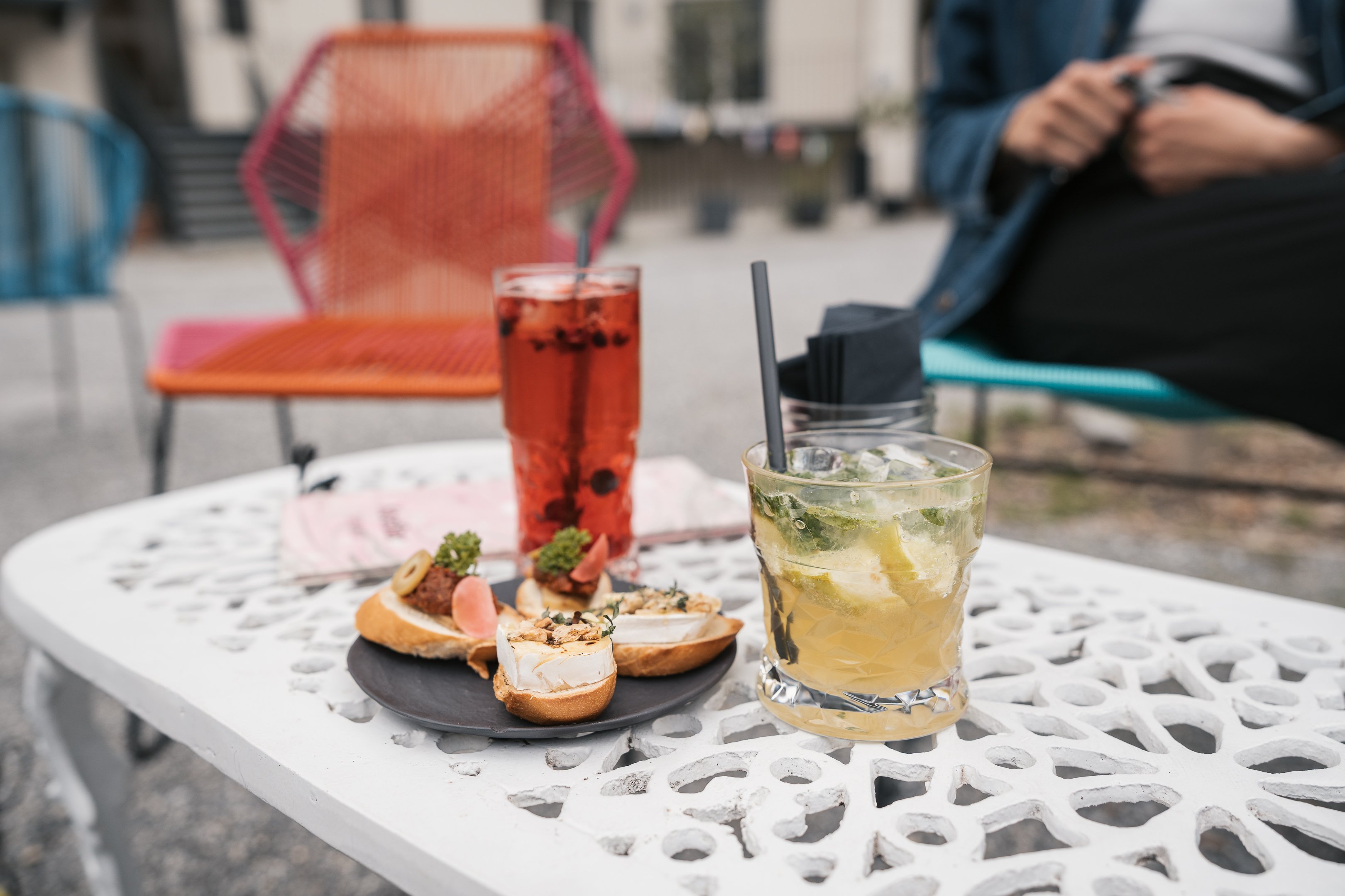 Un tavolo con due drink e quattro panini farciti.