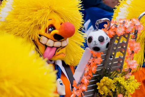 Guggenmusiker mit übergrosser Larve und gelben Haaren an Basler Fasnacht