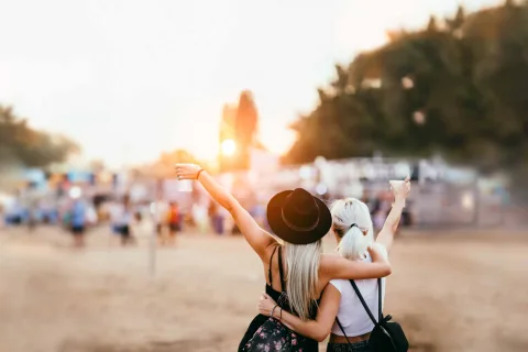 Zwei Personen bei Sonnenuntergang vor einer Open Air Bühne.