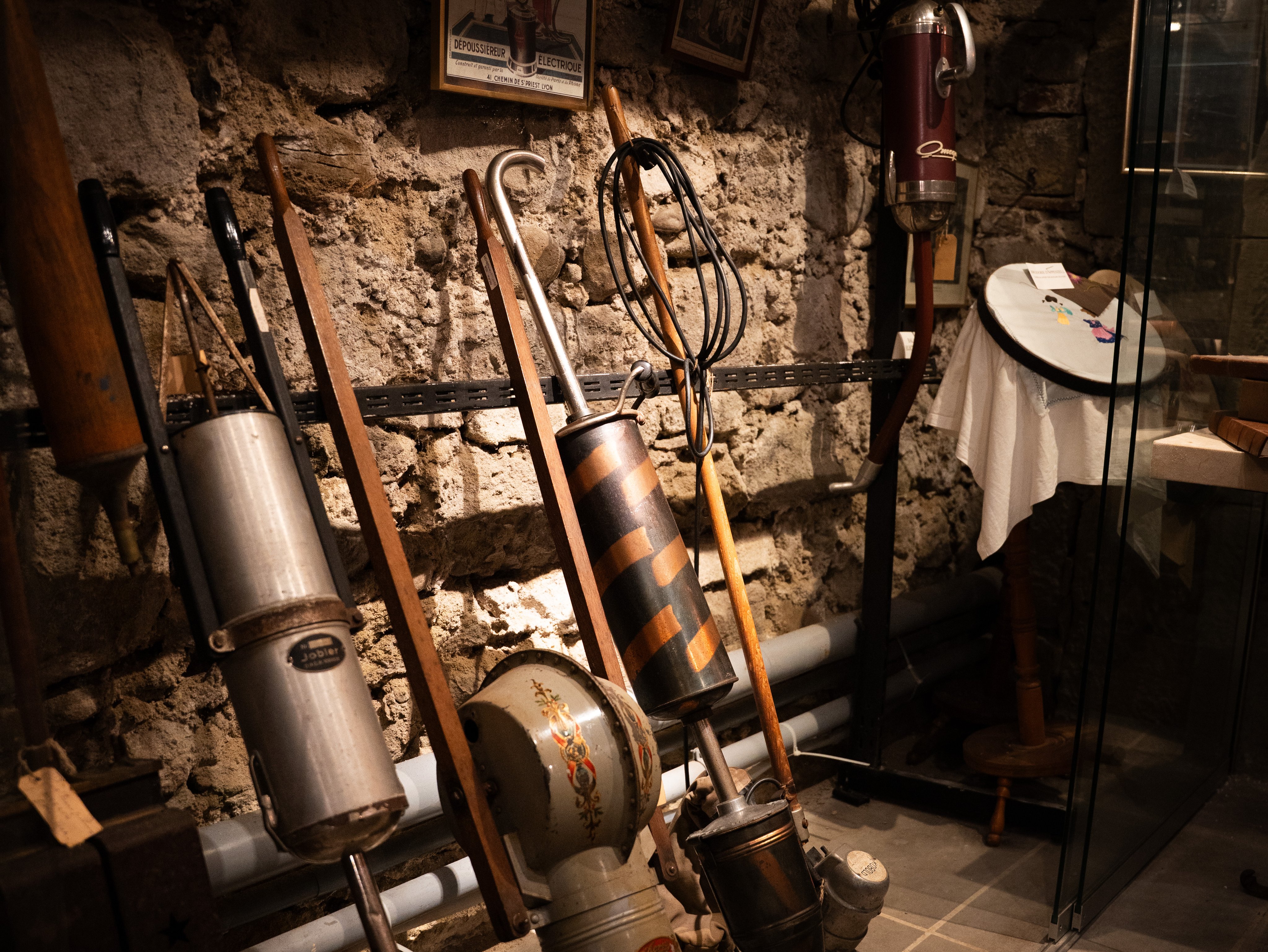 Contre un mur reposent divers appareils avec un long manche auquel sont attachés des conteneurs ronds.