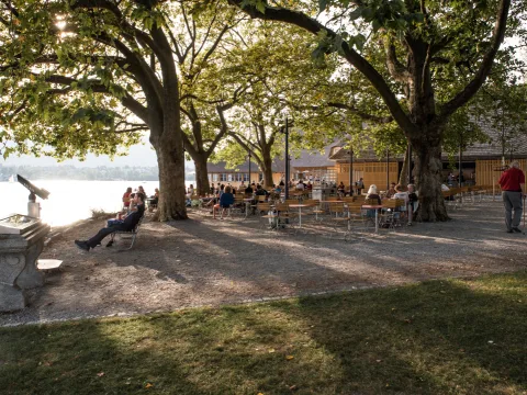 Aussenrestaurant Fischergarten bei Abendstimmung, im Hintergrund der See