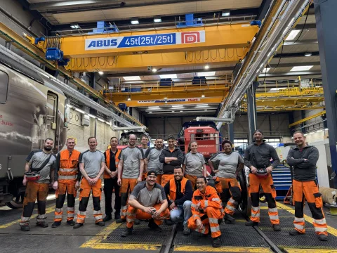 L’équipe de l’atelier de loc 2 pose sous le nouveau pont roulant et se réjouit de cet équipement tout neuf. Au milieu du groupe, on distingue Atreju Montaque, chef du projet.