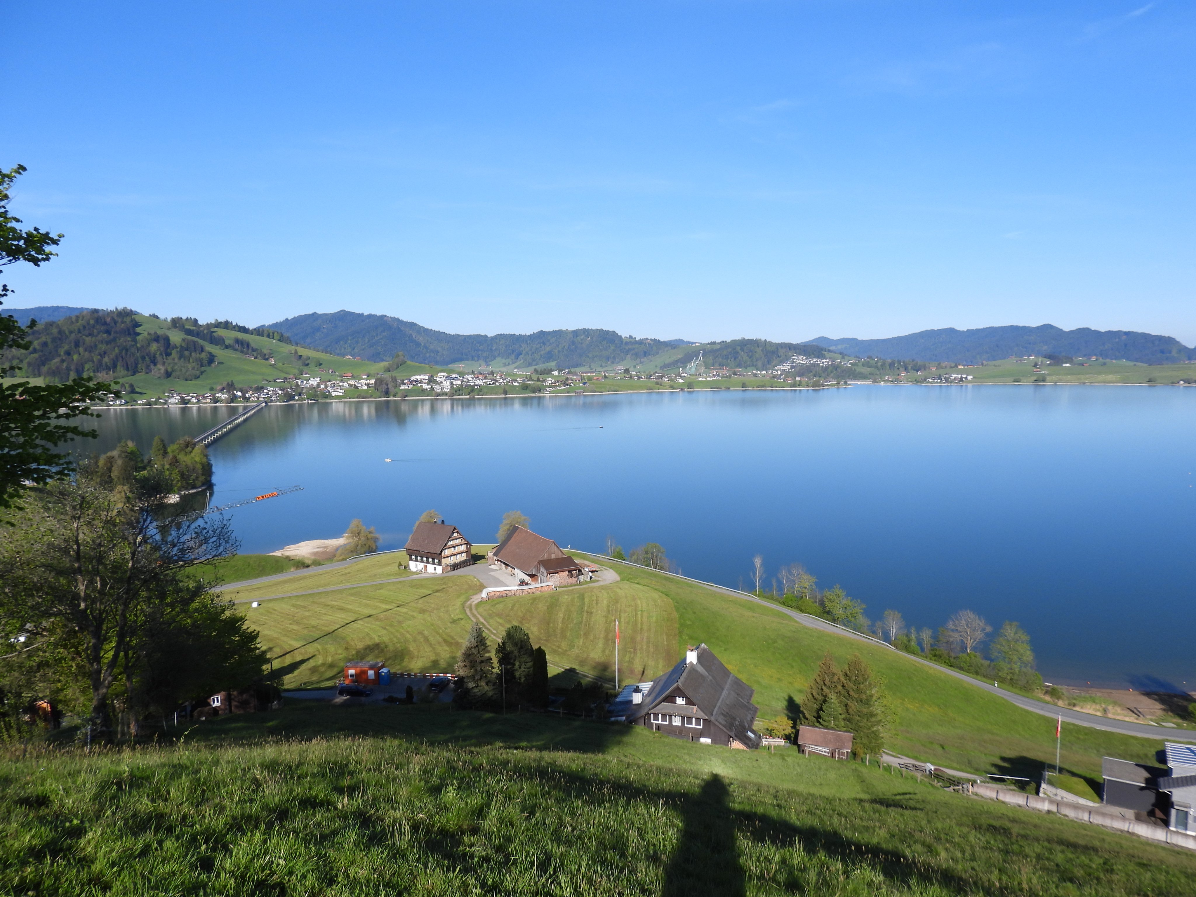 Auf dem Bild ist ein kleiner Teil des Sihlsees sowie die Staumauer von hinten ersichtlich. Es ist schönes, sonniges Wetter.    