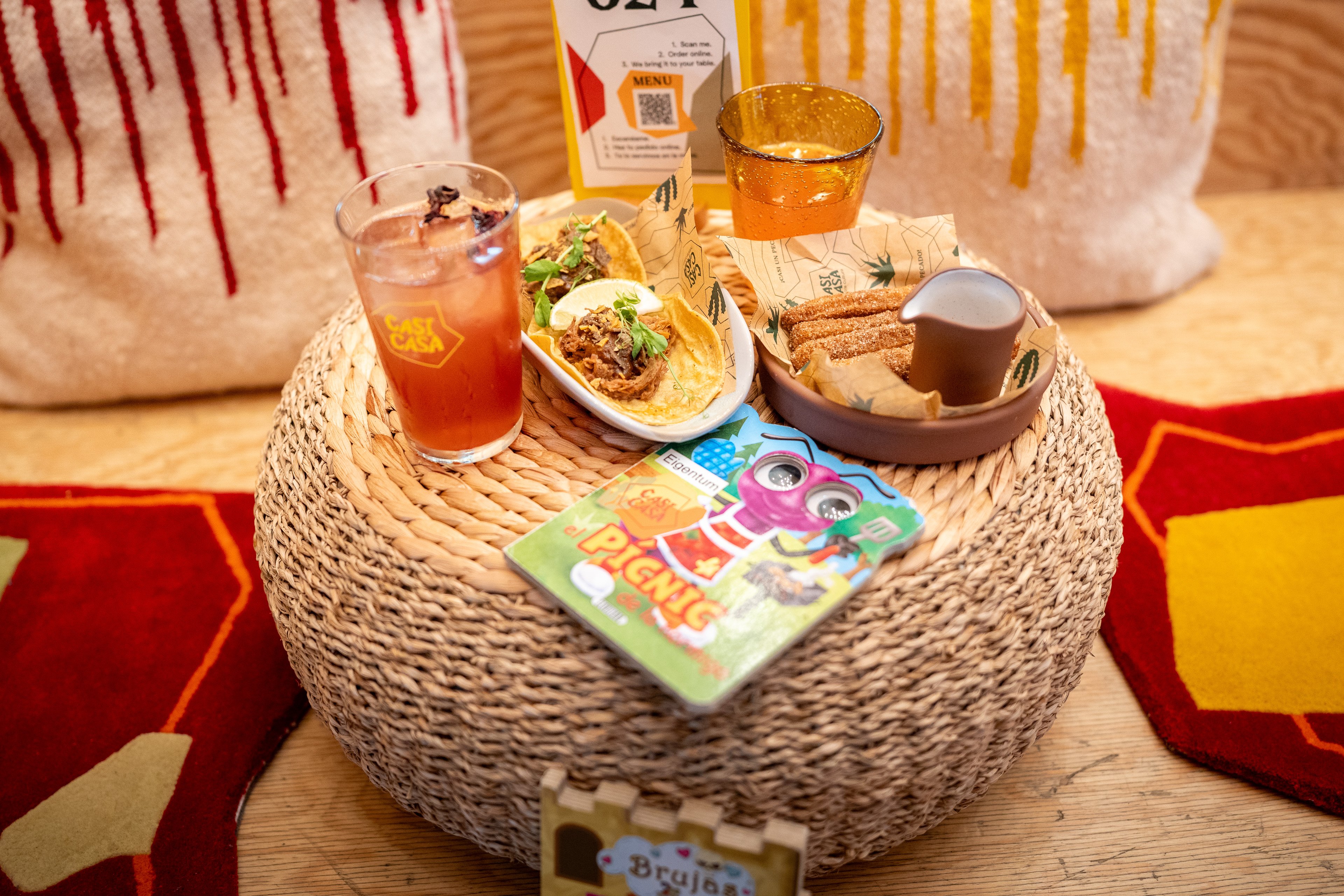 Essen, Getränke und Kinderbuch auf einem Tisch im Restaurant Casi Casa.  