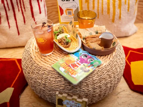 Essen, Getränke und Kinderbuch auf einem Tisch im Restaurant Casi Casa.