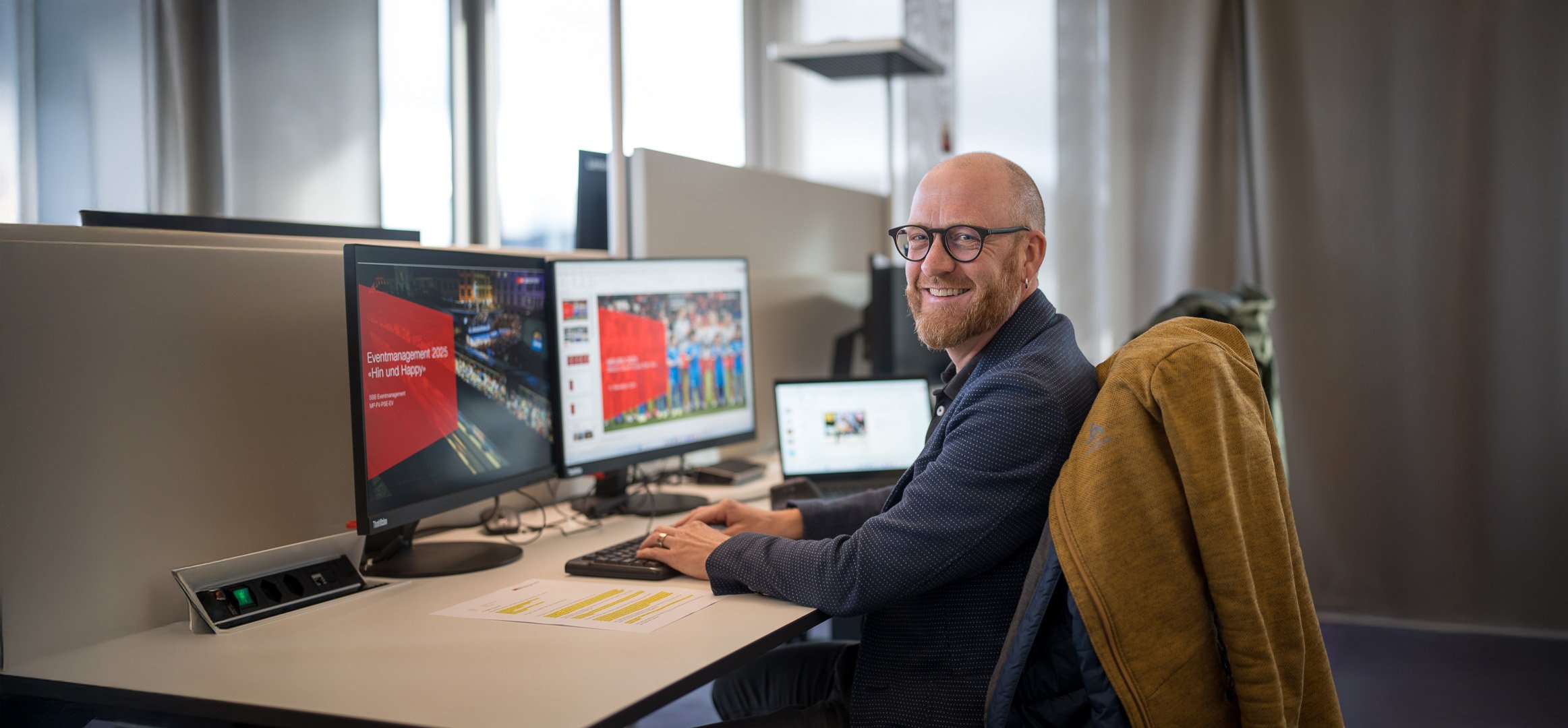 Florian Kurt, assis à son poste de travail, regarde la caméra.