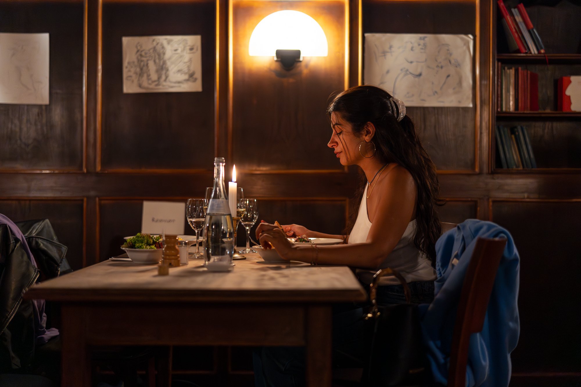 Frau sitzt an einem Tisch und isst. 