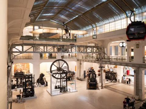 La grande sala espositiva del Museo della tecnica di Vienna con macchine, locomotive e velivoli del passato.