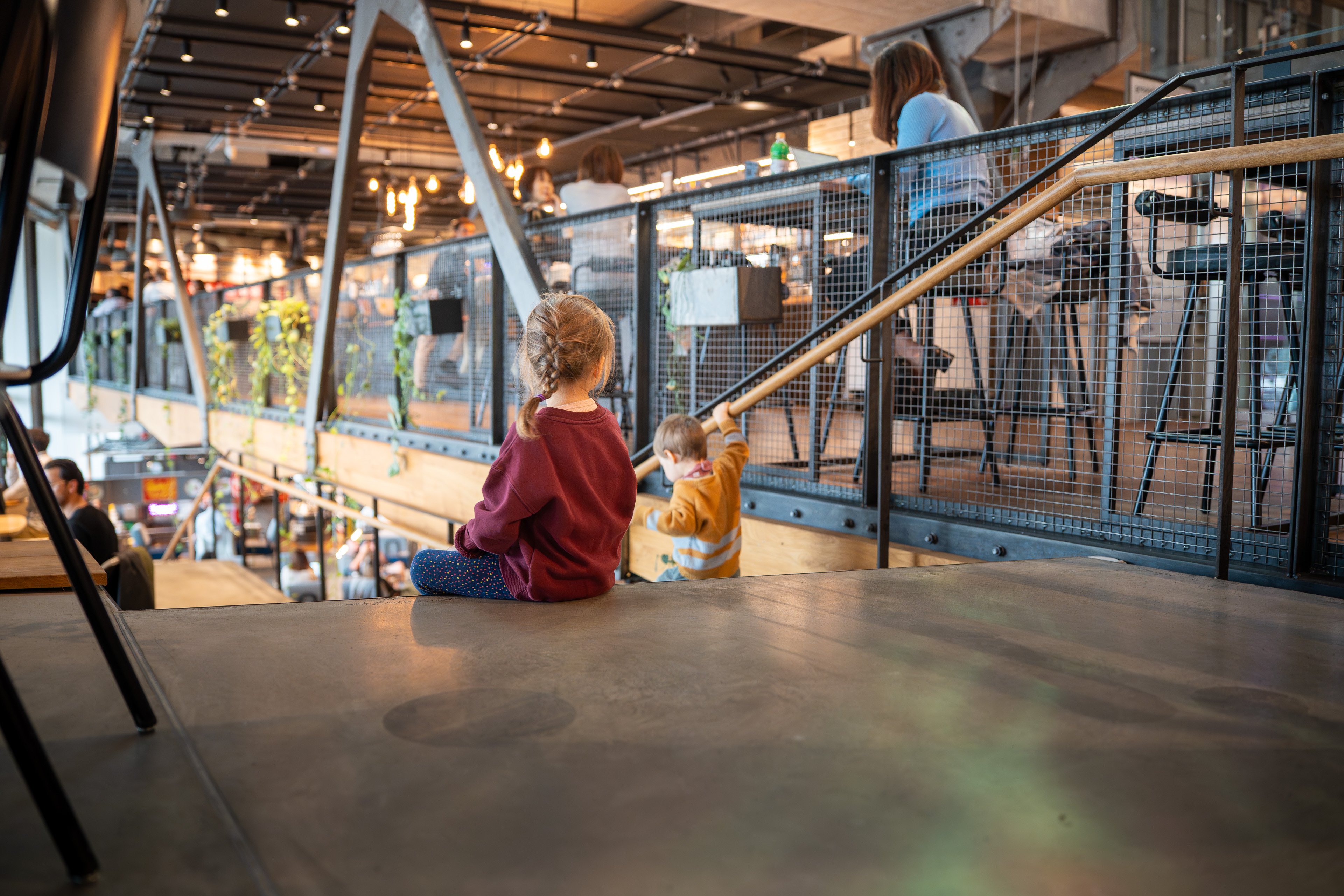Zwei Kinder auf der Treppe des Restaurants Bridge. 