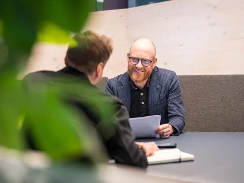 Florian Kurt est assis à une table bleu foncé dans les bureaux des CFF.