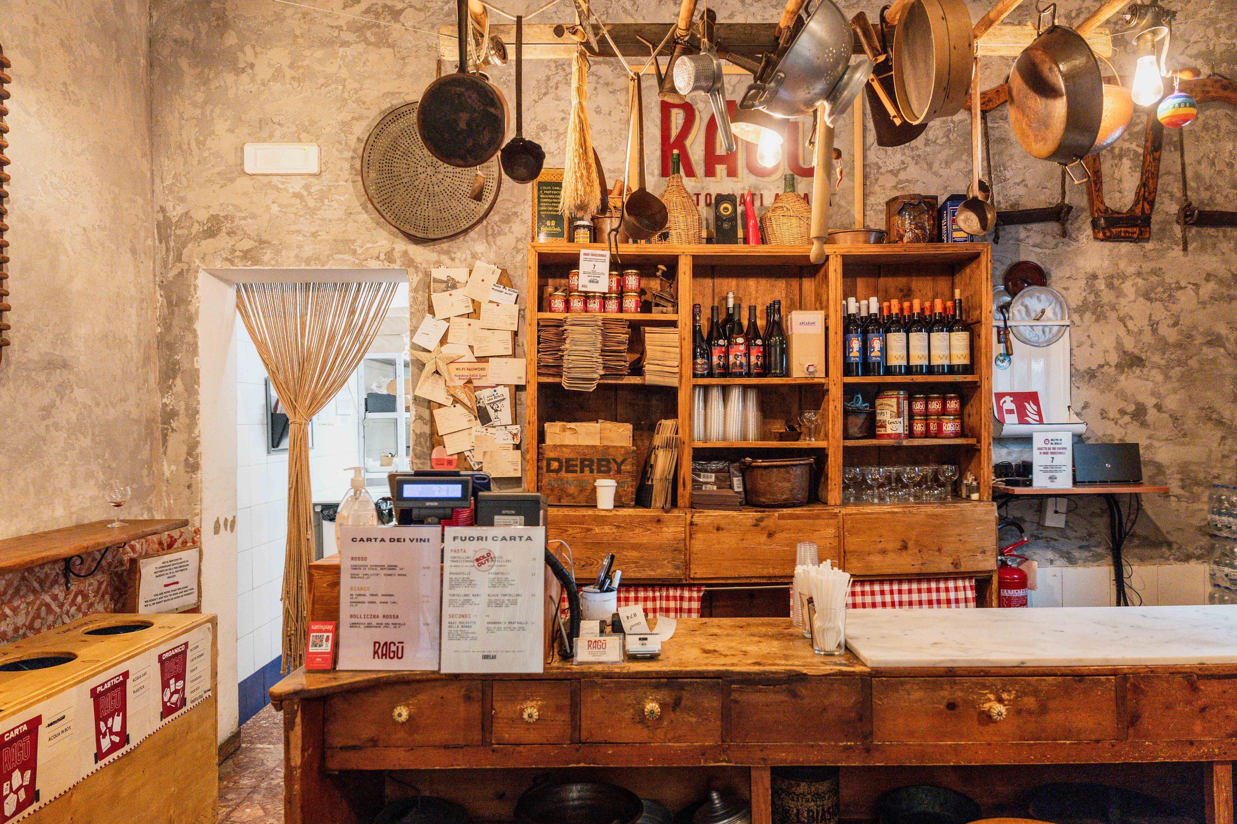 Rustic bistro with wooden furniture, shelves full of bottles and decoration.