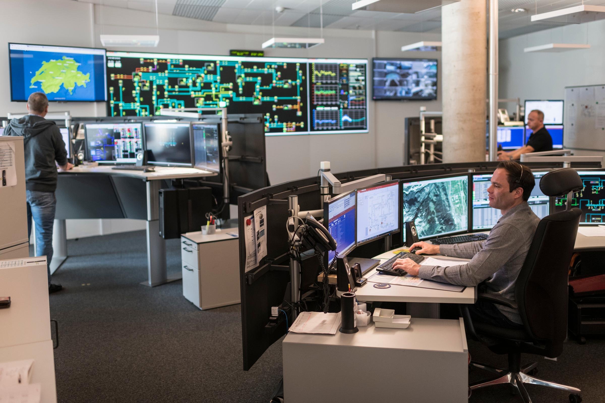 Tre uomini lavorano davanti agli schermi nel posto direttivo Energia.