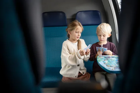 due bambini giocano a carte sul treno