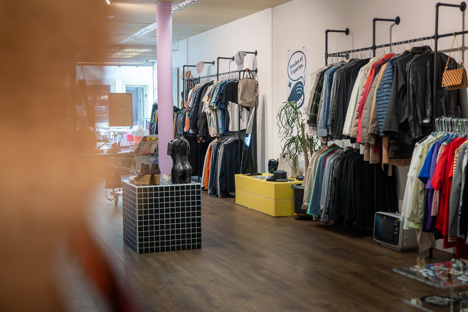 Eine Ladenfläche mit üppig gefüllten Kleiderstangen und dekorativen Elementen.