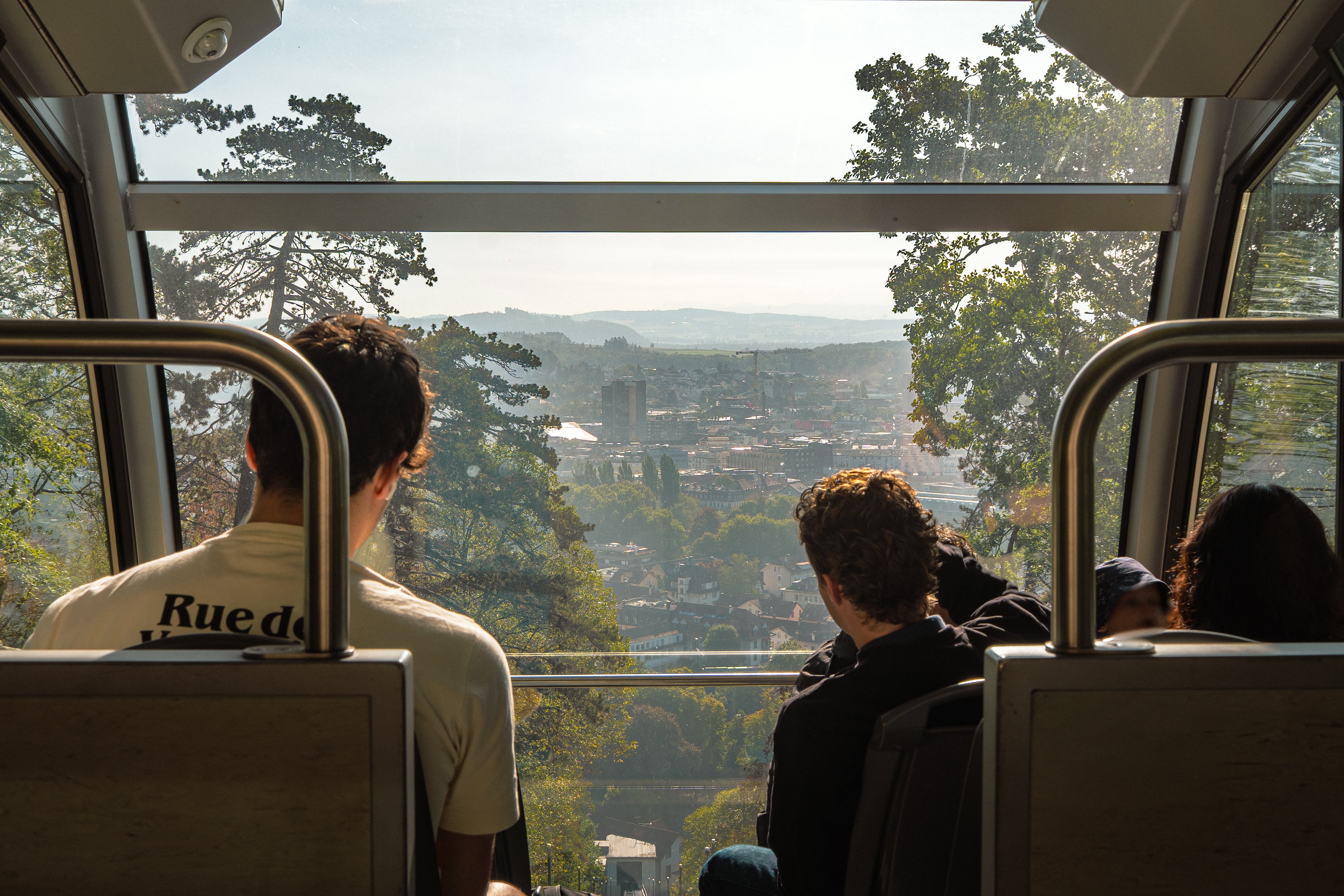 Vista dalla funicolare di Macolin, oltre i passeggeri seduti, sulla città di Bienne.