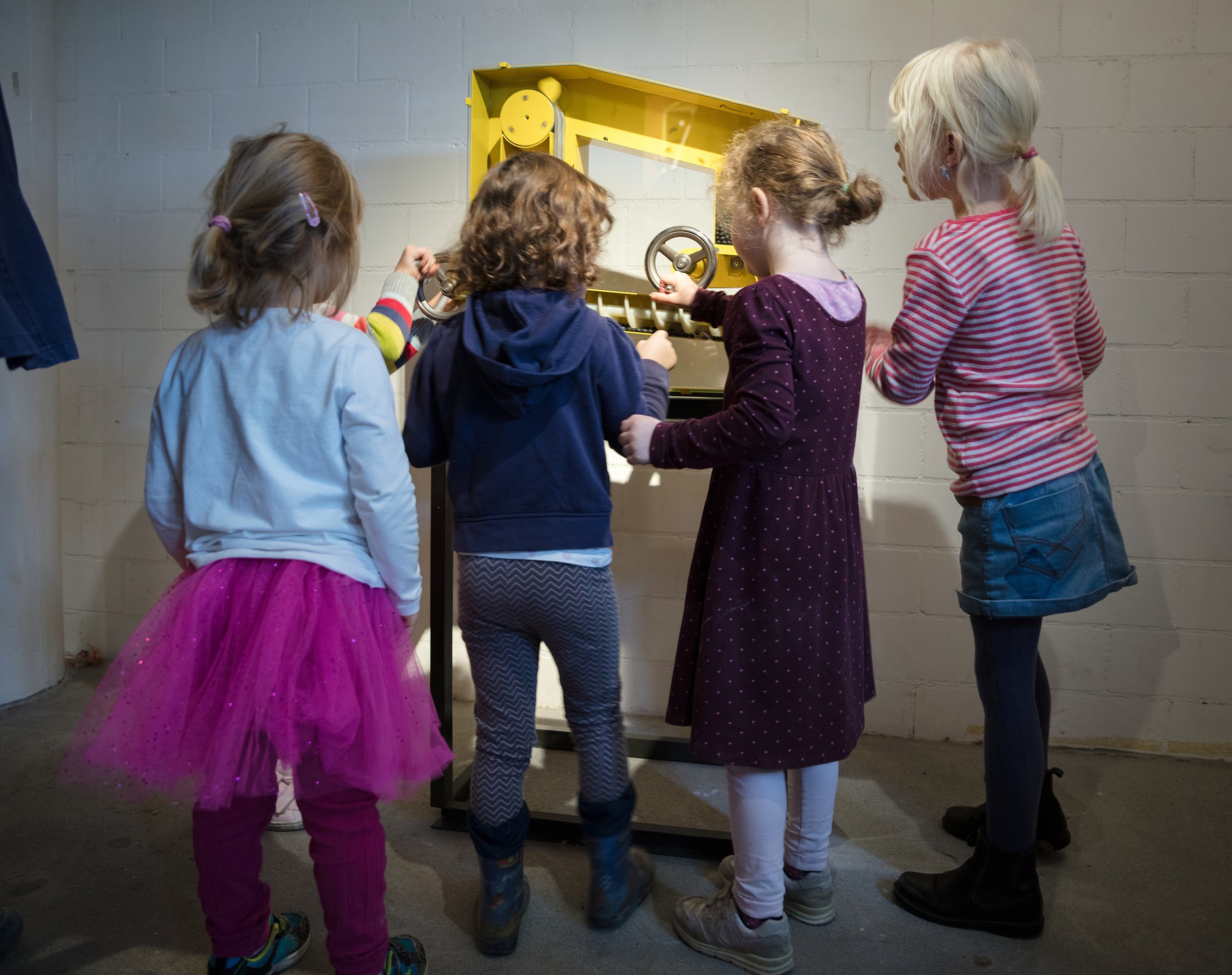 Vier Kinder stehen vor einer alten Getreidemühle. 
