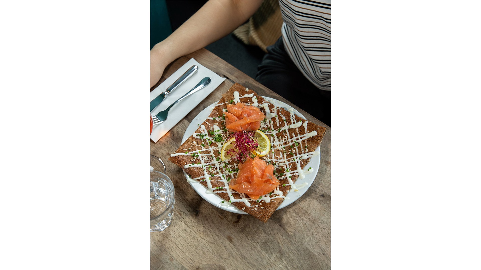 Crêpe farcita con salmone affumicato su un piatto.