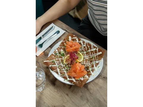 Crêpe farcita con salmone affumicato su un piatto.