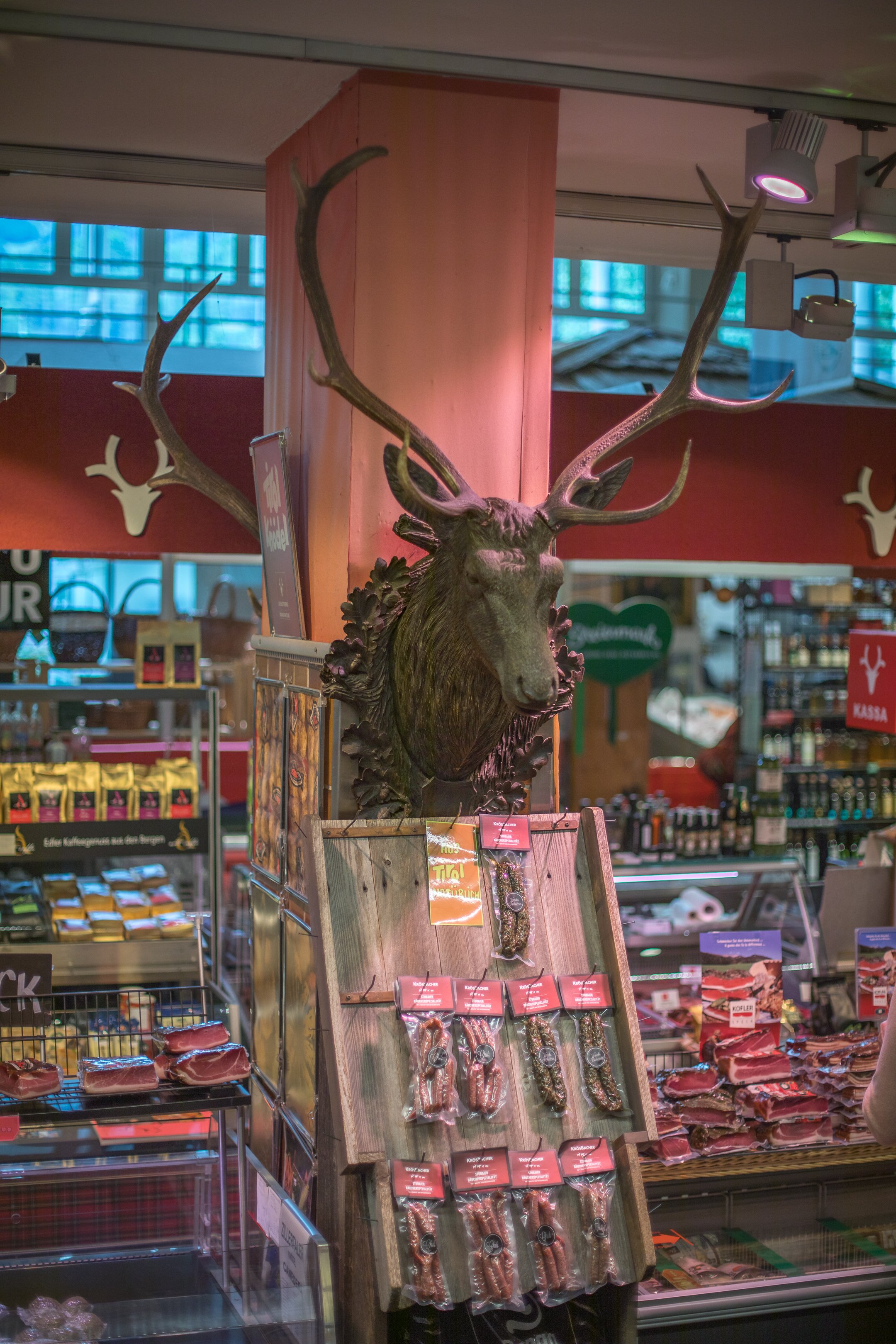 Un assortimento di speck, con sopra una testa di cervo.