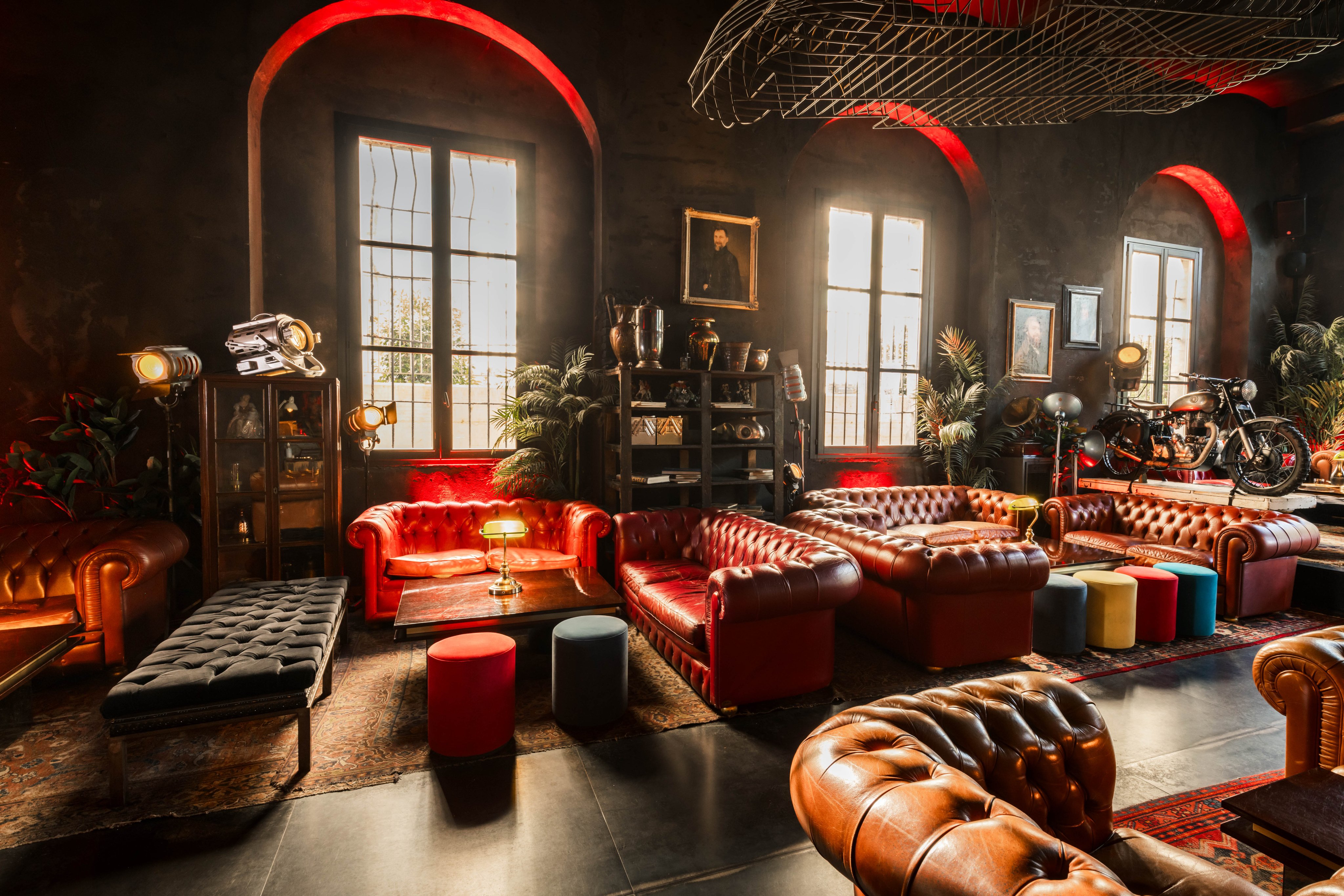 Locale con illuminazione d’atmosfera e grandi divani e una moto come decorazione.