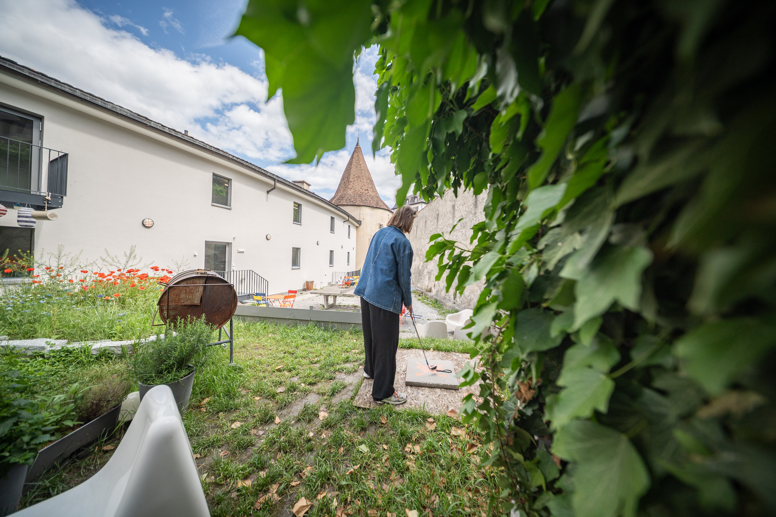 Una donna in un cortile con in mano una mazza da golf.