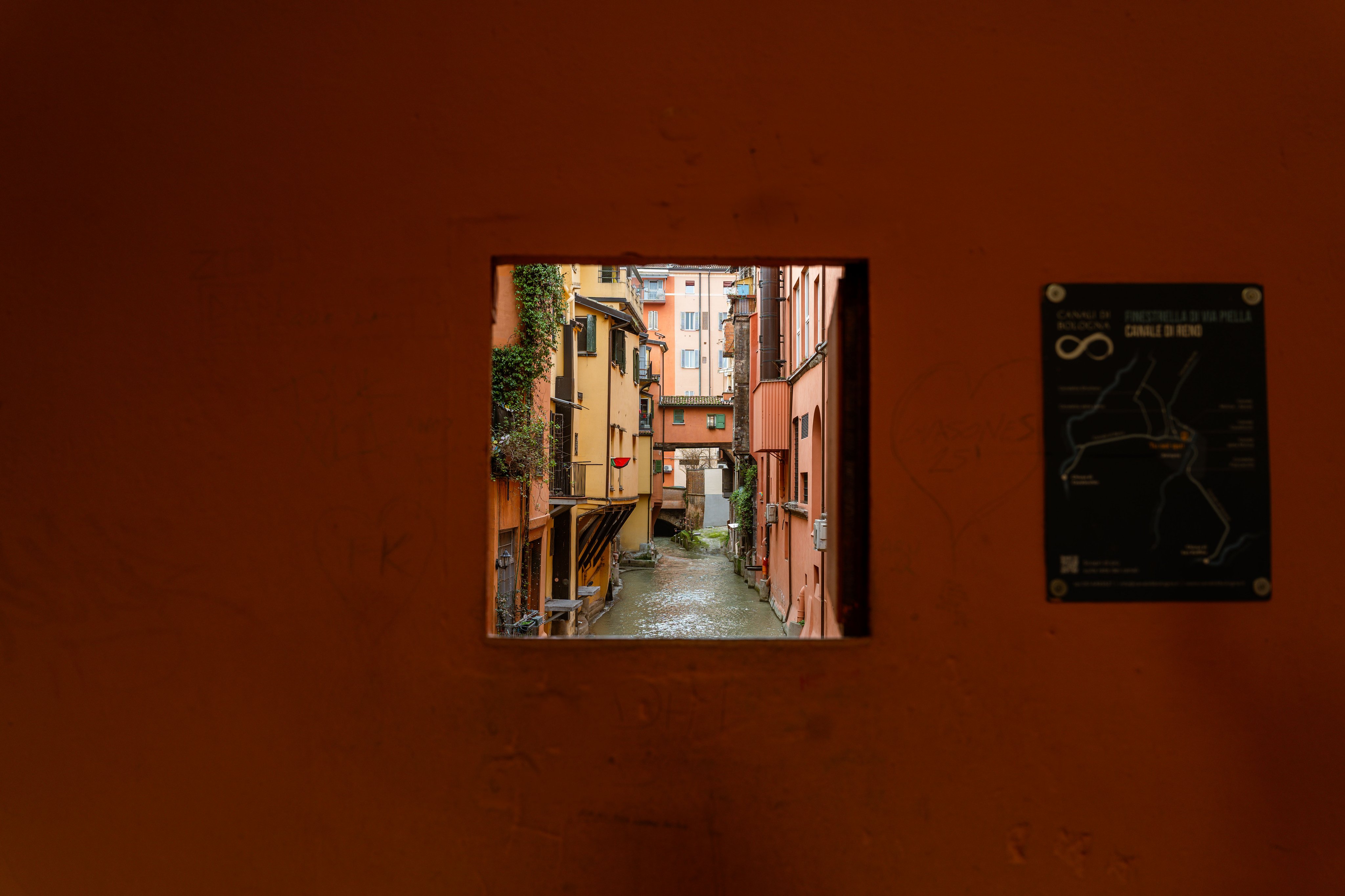 A window in a house wall overlooking a canal