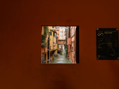 A window in a house wall overlooking a canal