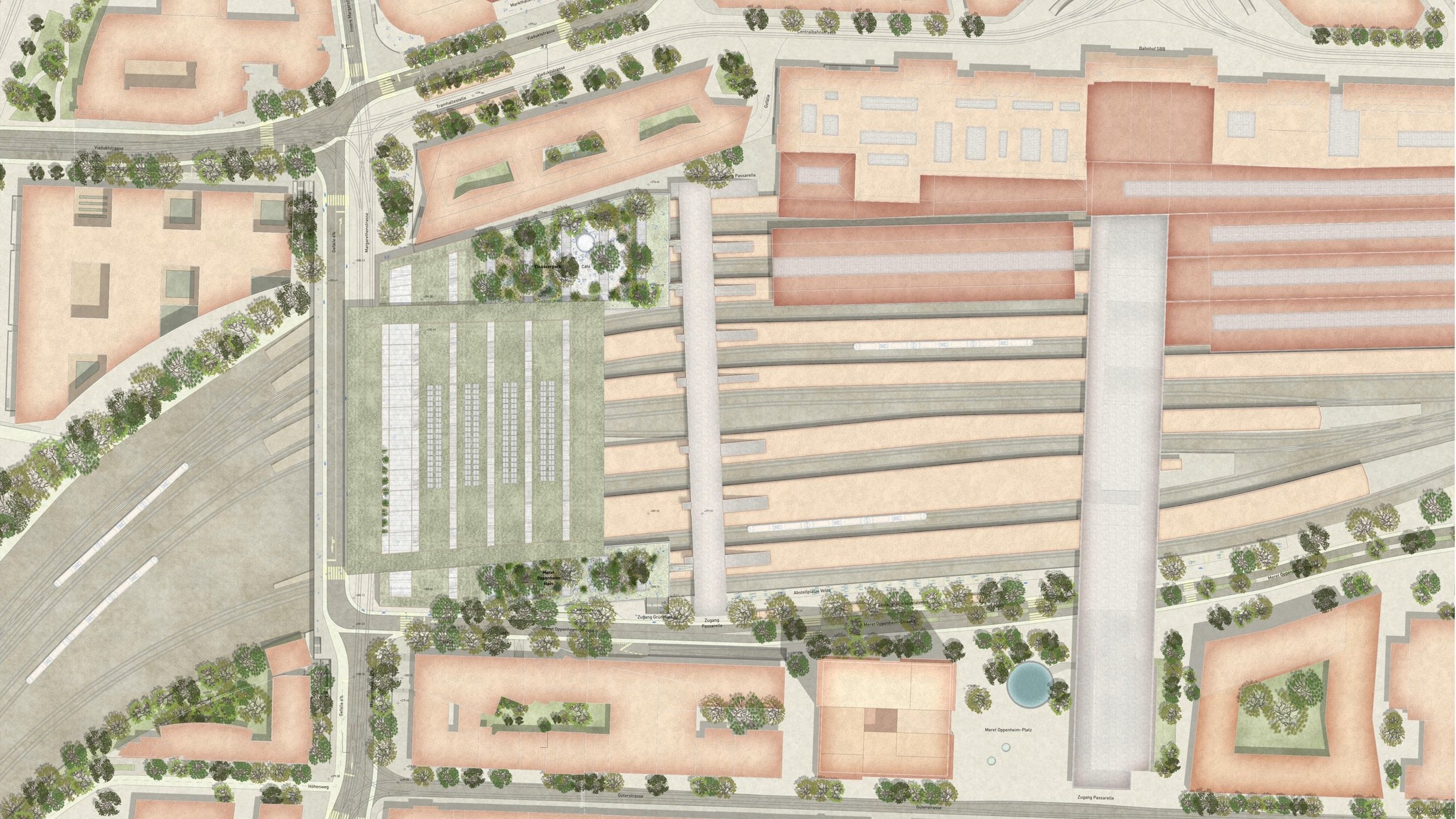 Das Bild zeigt eine detaillierte Luftaufnahme eines Bahnhofsbereichs mit mehreren Gleisen, Perrons und umliegenden Gebäuden. Es gibt Bäume und Grünflächen um den Bahnhof herum. Die Straßen und Wege sind ebenfalls deutlich zu erkennen.