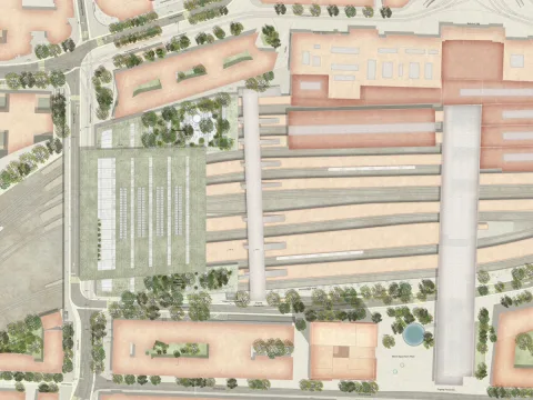 Das Bild zeigt eine detaillierte Luftaufnahme eines Bahnhofsbereichs mit mehreren Gleisen, Perrons und umliegenden Gebäuden. Es gibt Bäume und Grünflächen um den Bahnhof herum. Die Straßen und Wege sind ebenfalls deutlich zu erkennen.