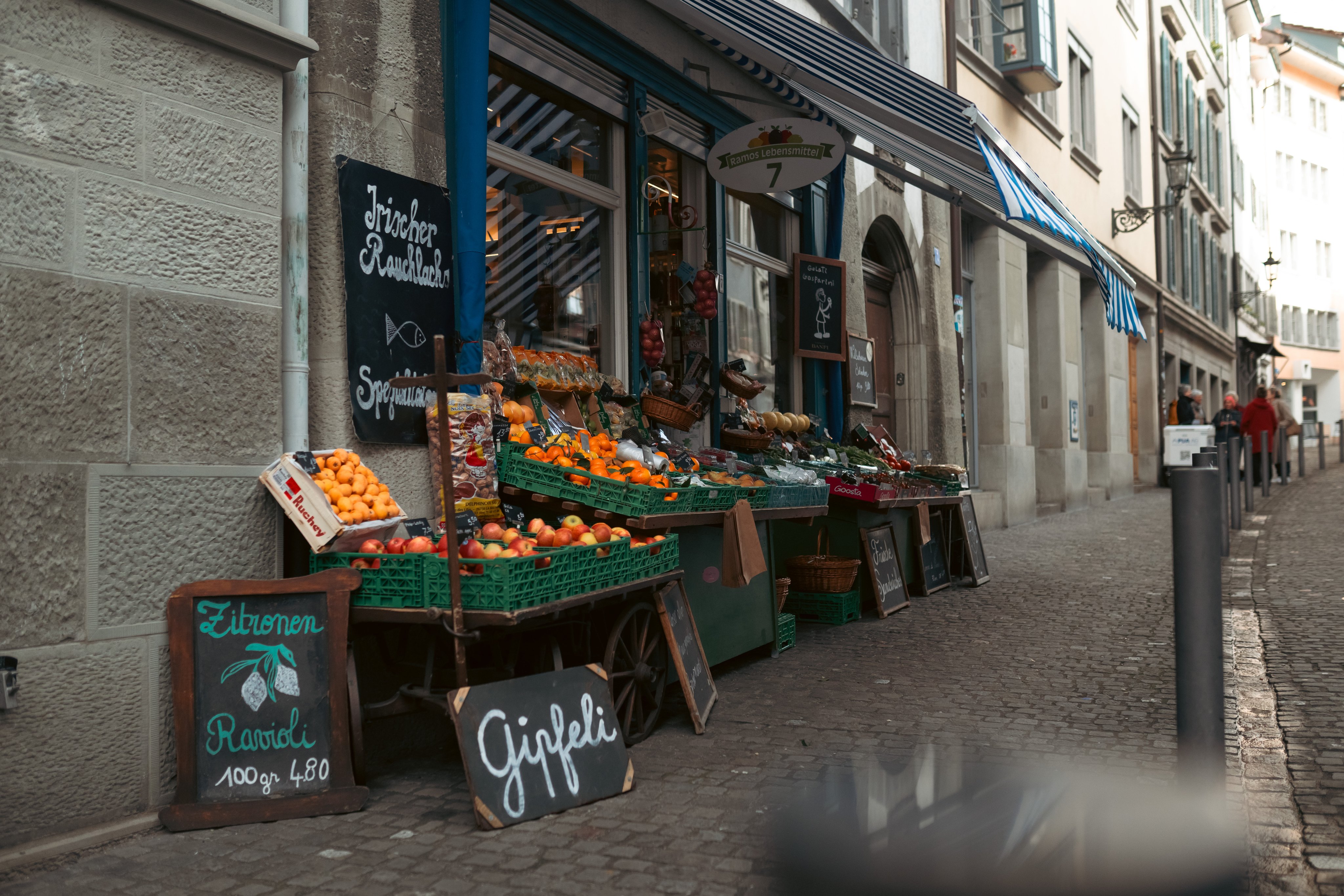 Une épicerie fine a placé devant sa porte des fruits et légumes ainsi que des délicatesses.  