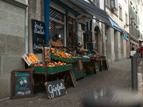 Une épicerie fine a placé devant sa porte des fruits et légumes ainsi que des délicatesses.