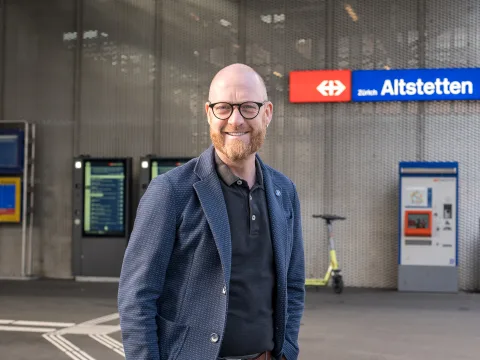 Florian Kurt devant la gare d’Altstetten. Il regarde la caméra.