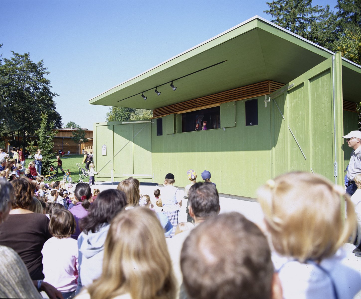 Kinder sitzen vor einem Kasperlitheater