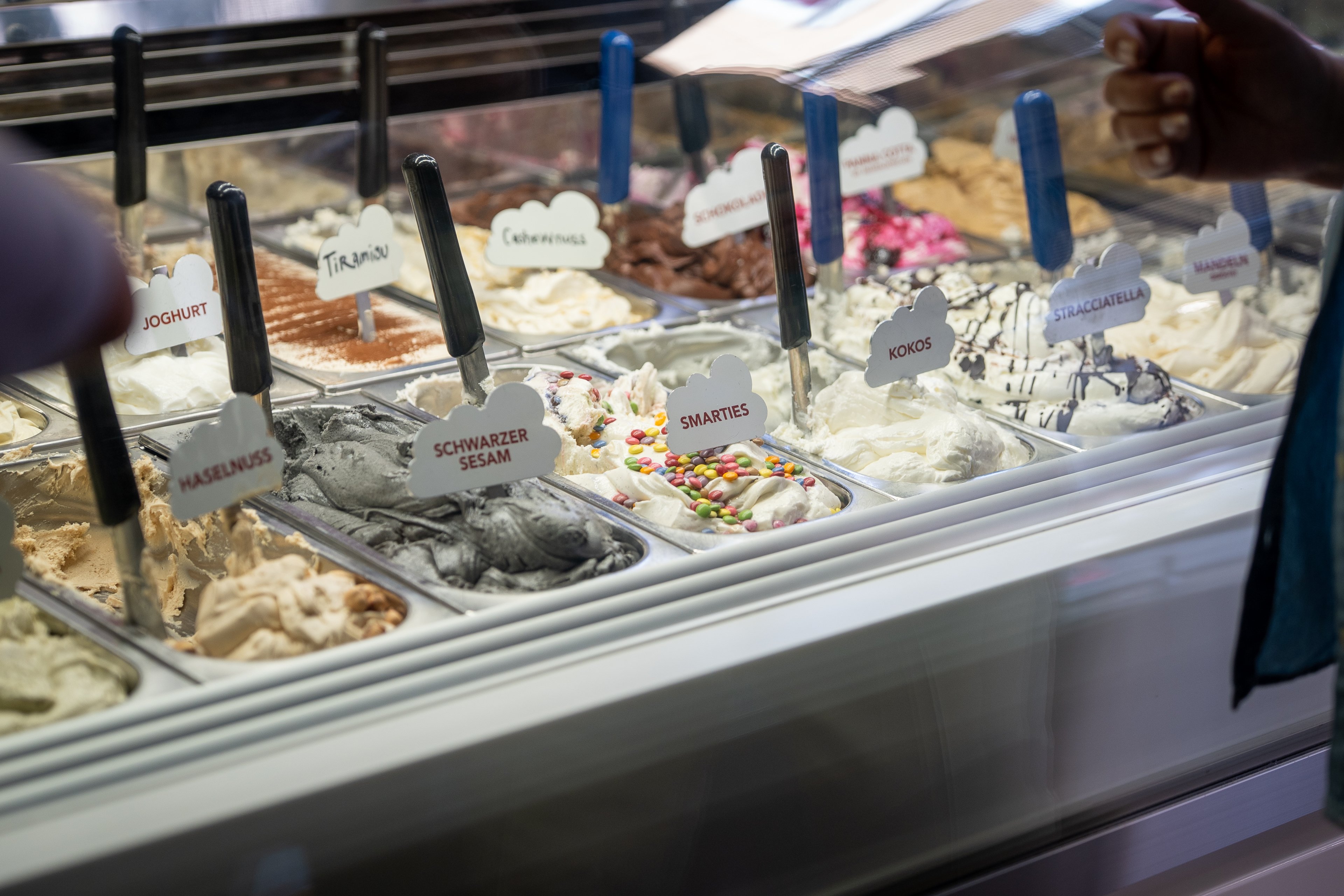 Eine Vitrine mit zahlreichen Glacen in metallenen Behältern.